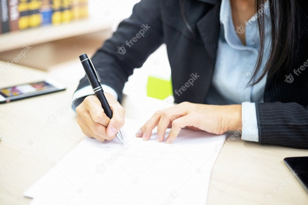 La empresaria firma los documentos. Concepto de tratamiento fotográfico oblicuo